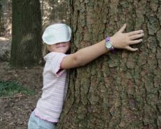 Mädchen umarmt einen Baum